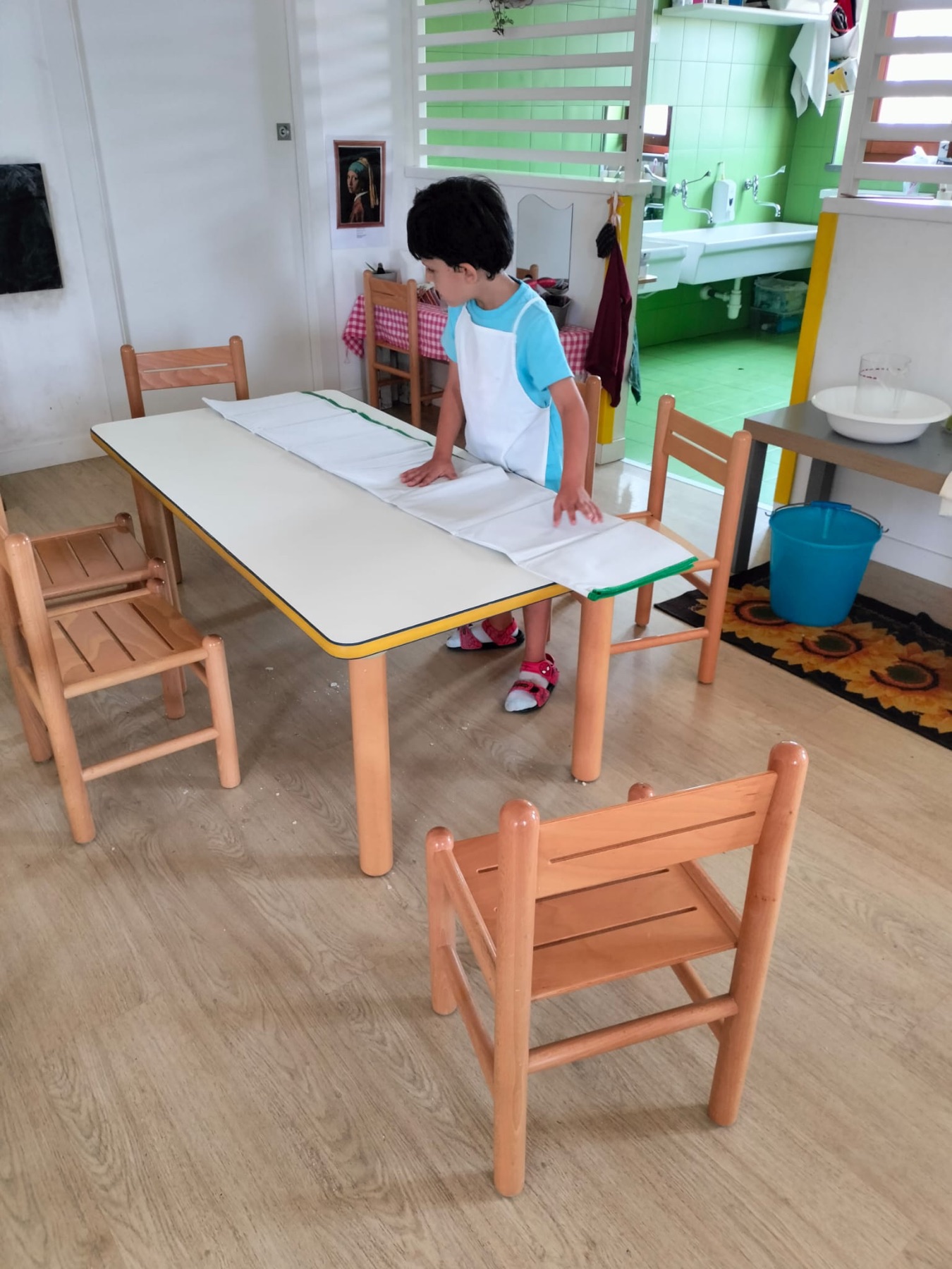 Bambino che prepara il tavolo durante un'attività di vita pratica