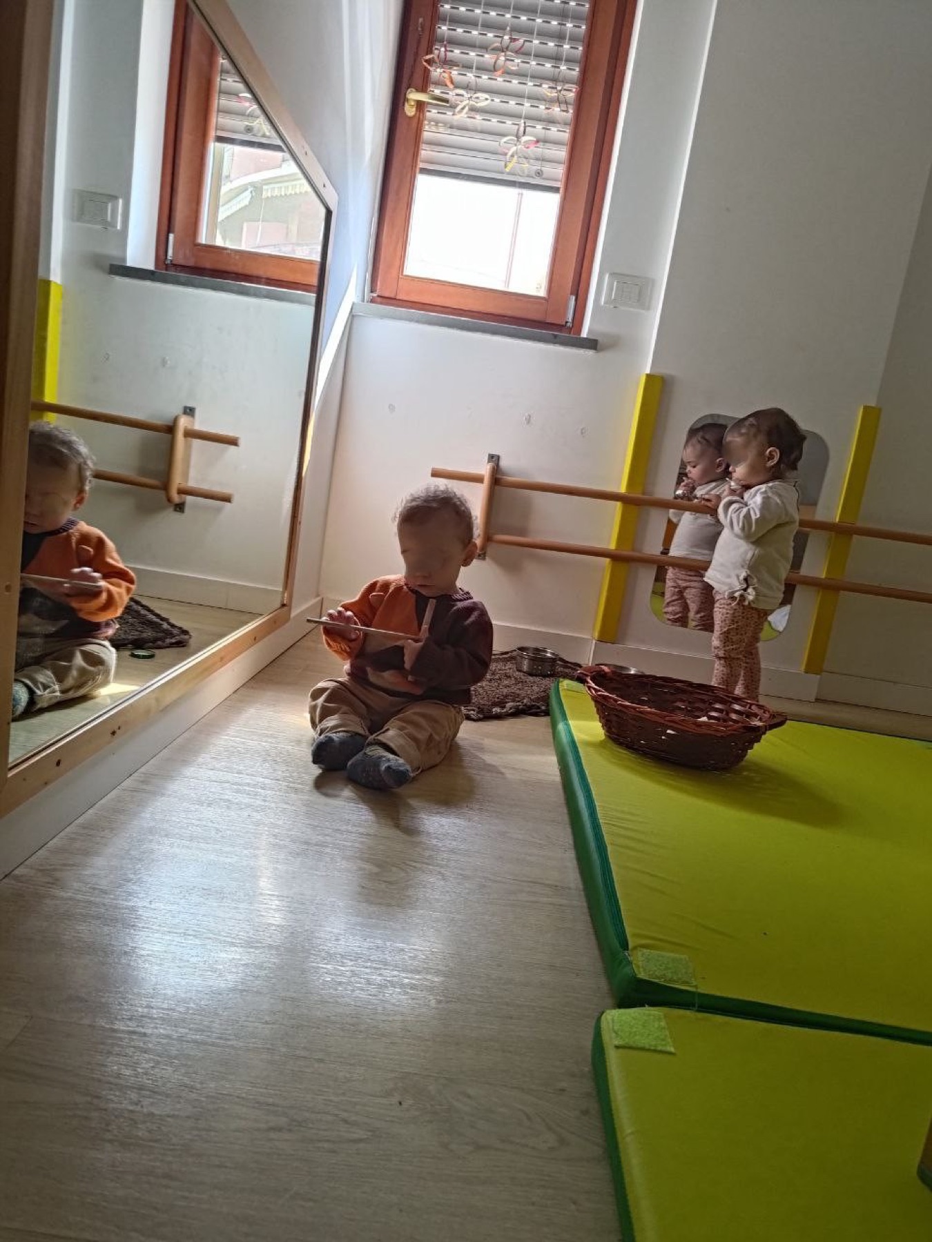 Bambini lattanti che esplorano lo spazio davanti allo specchio