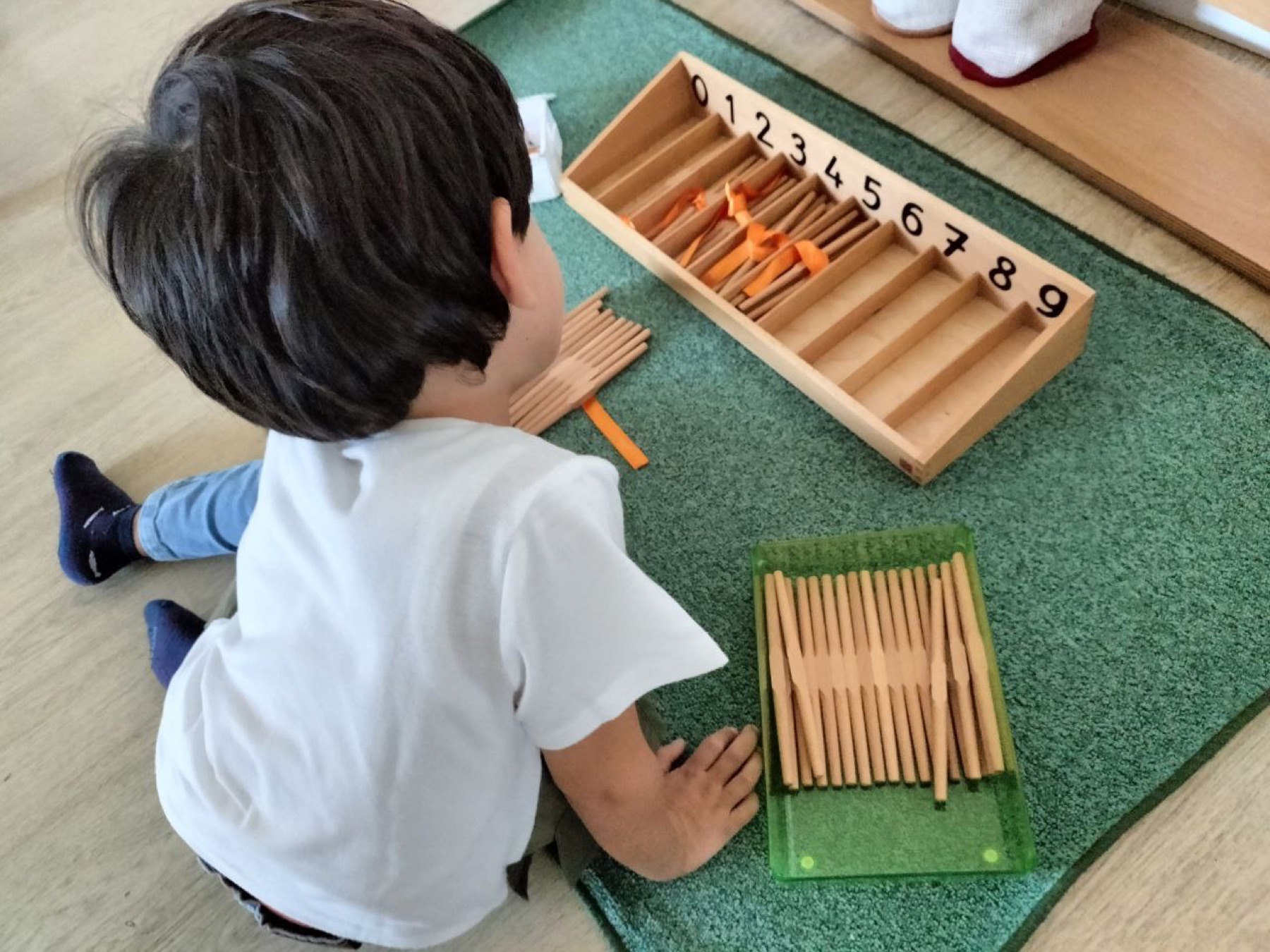 Bambino al lavoro con il materiale Montessori per la matematica